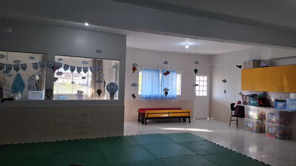Sala de atividades decorada com balões e nuvens de papel